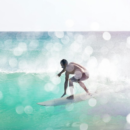 surfer riding a wave in a tropical area green water